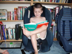 The Boy reading..that is just a small part of my library right behind him.